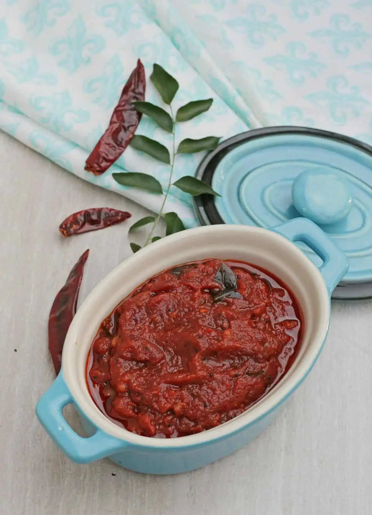 kara chutney in a bowl with red chilies and curry leaves in side