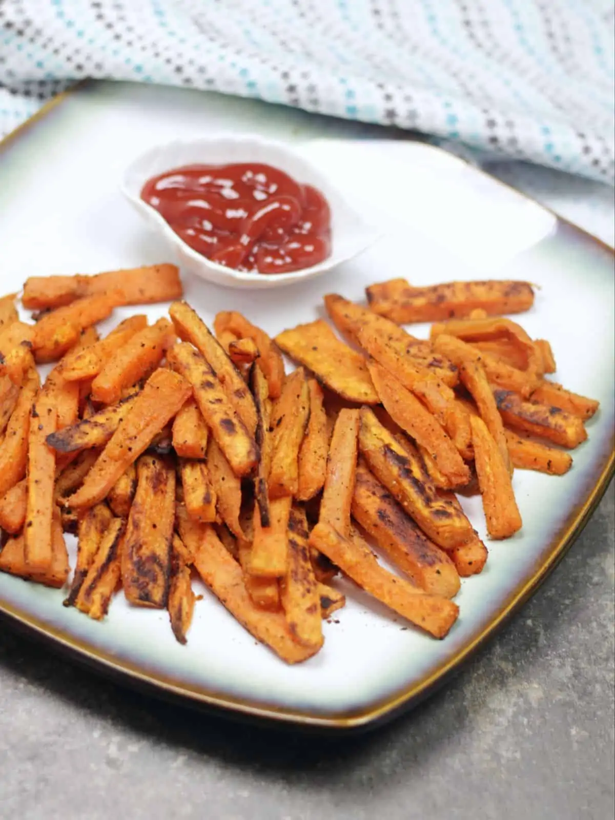 close up shot of sweet potato fries with ketchup. 