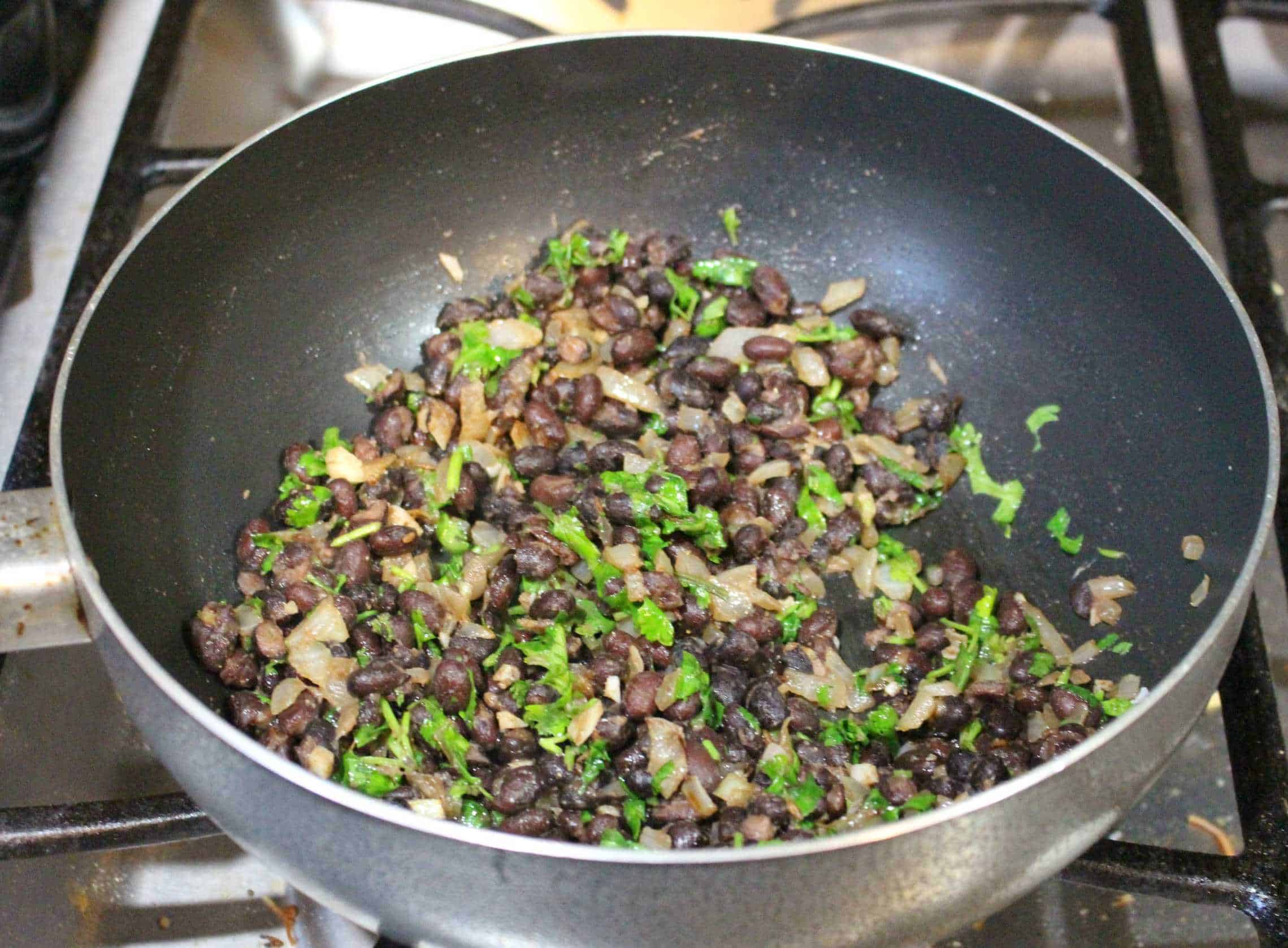 Black beans, onion and cilantro in a pan