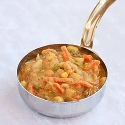 Vegetable curry in a bowl with handle.