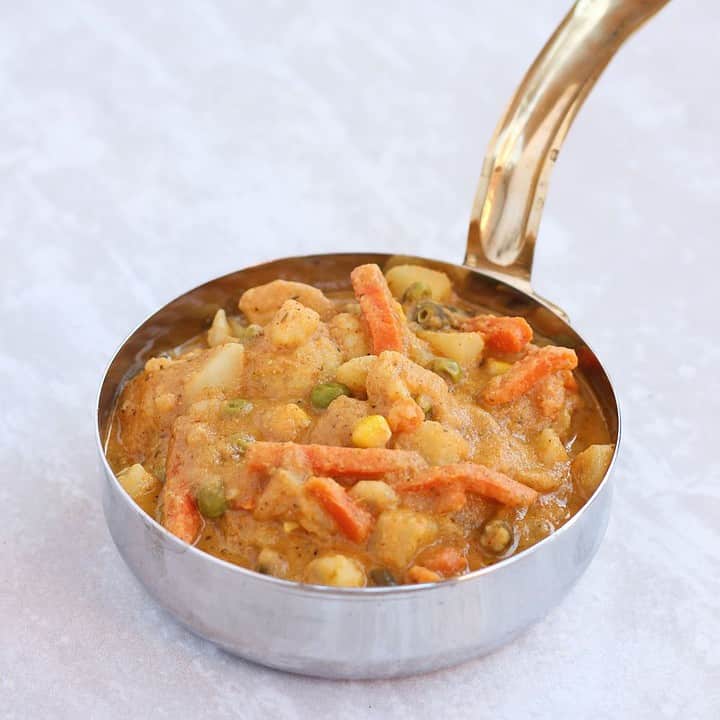 Vegetable curry in a bowl with handle.