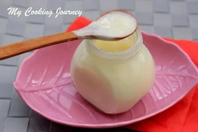 Condensed milk in a jar and spoon - Side View