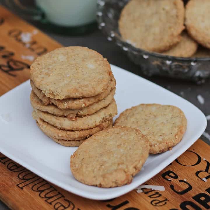 stacked coconut and sesame cookies in a plate.