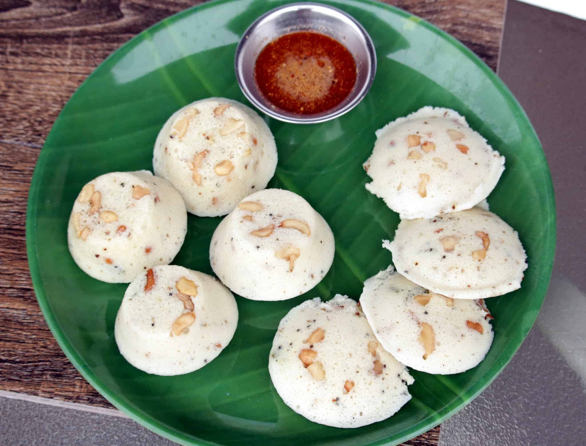 Kanchipuram idli in a green plate with a side of Milagai Podi