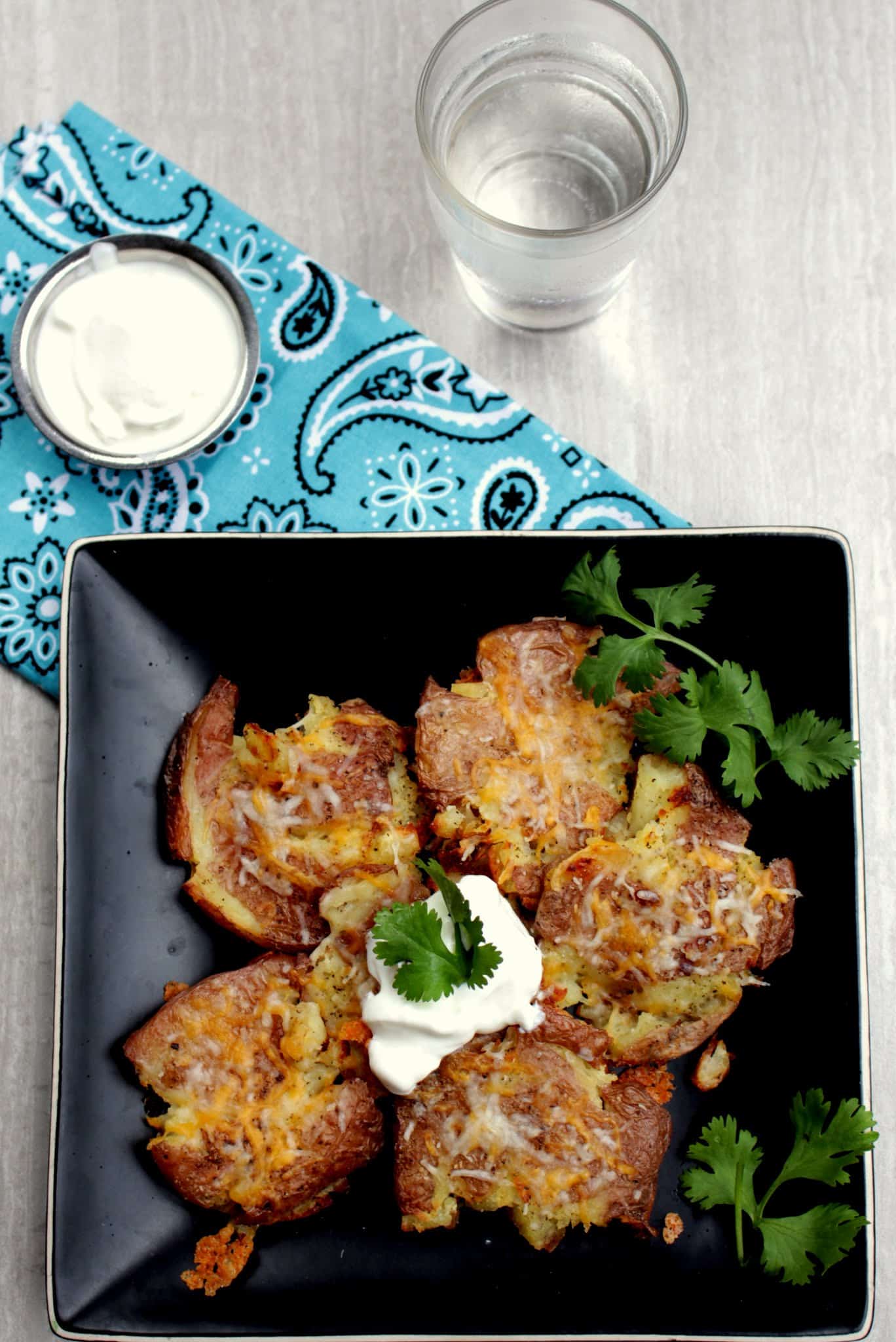 Smashed Potatoes in plate with cheese and sour cream