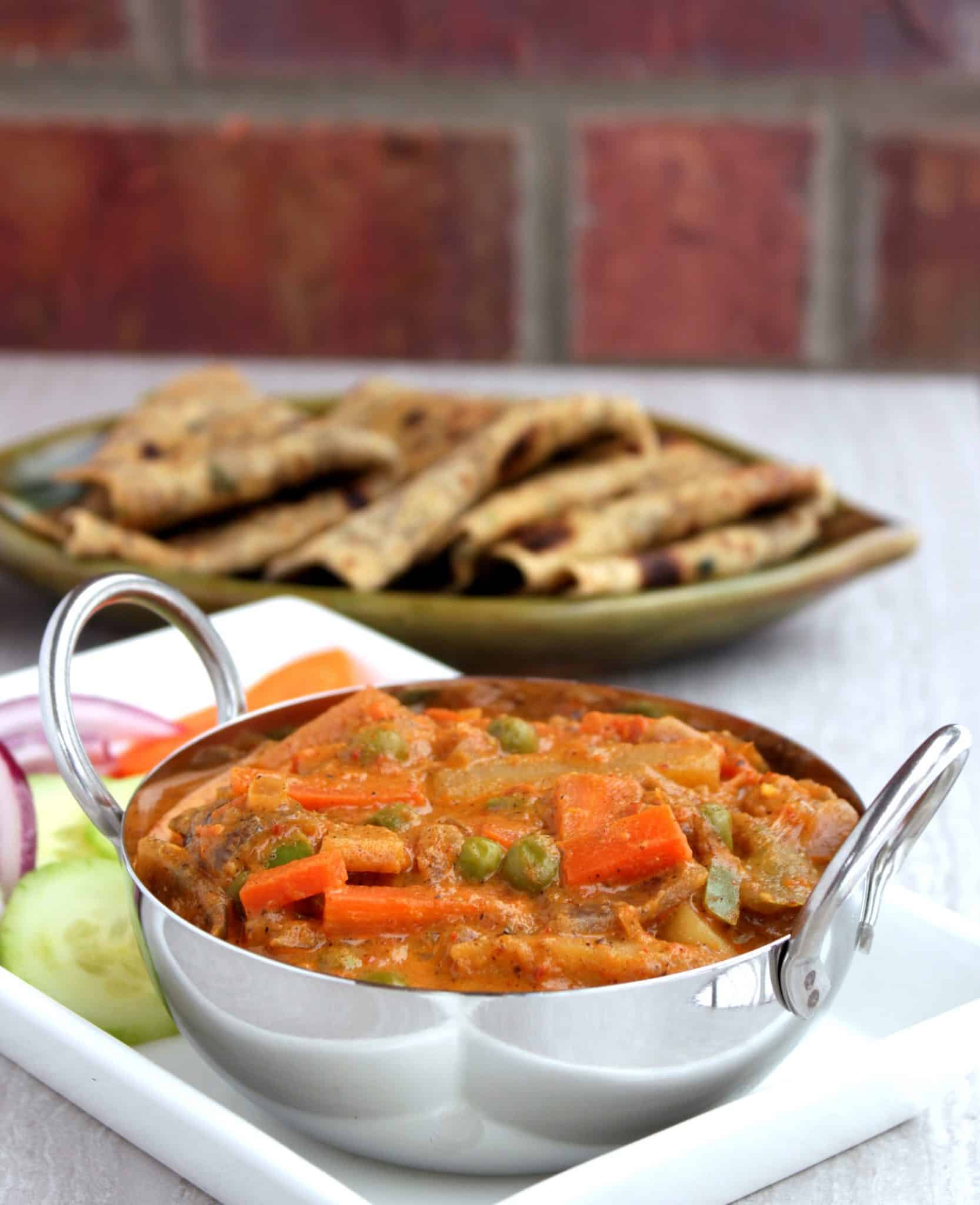 Kadai Vegetable Gravy with cucumber, tomato, Onion and carrot on the side - Side view