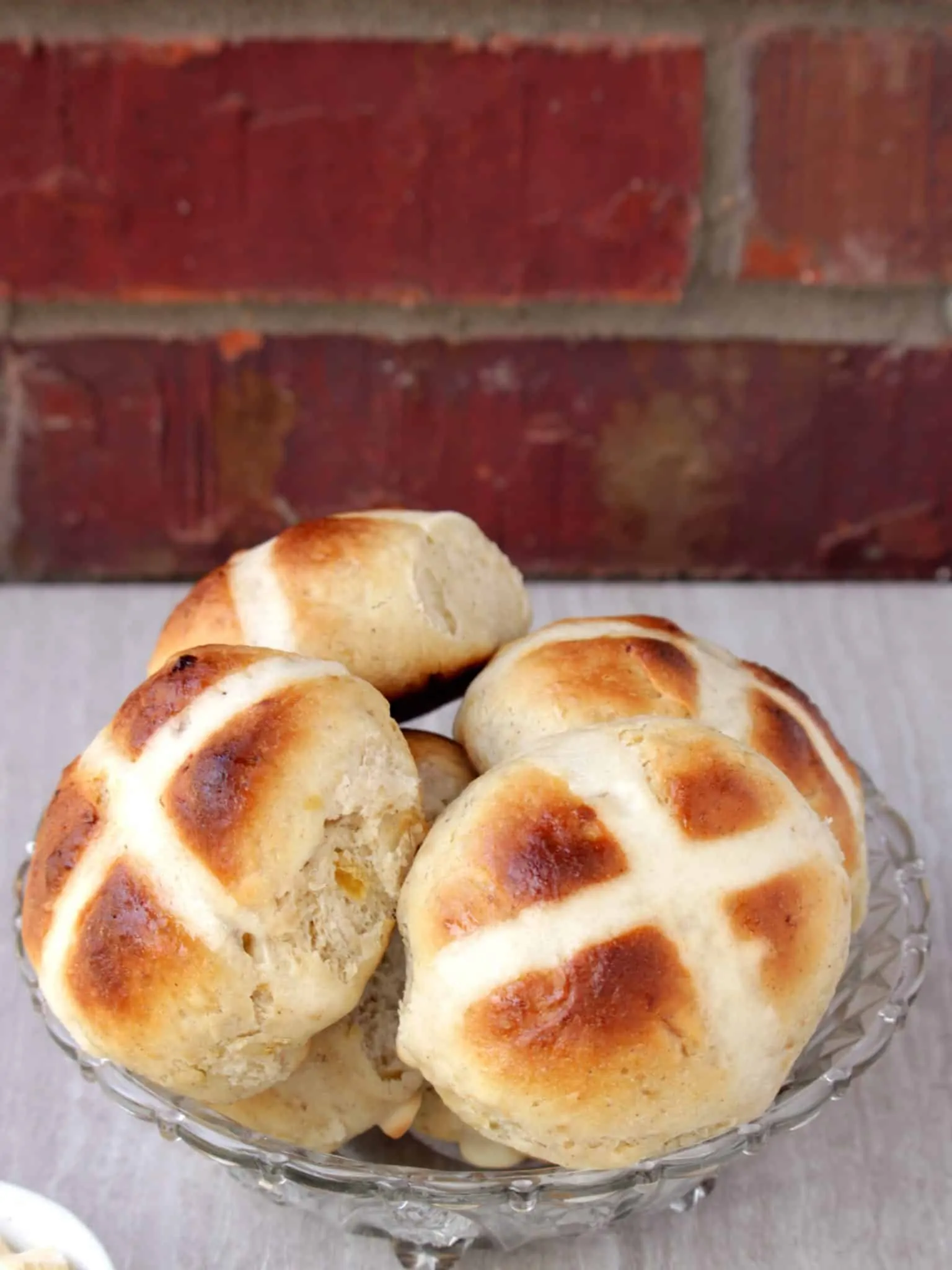 Hot Cross Buns in a glass bowl stacked.