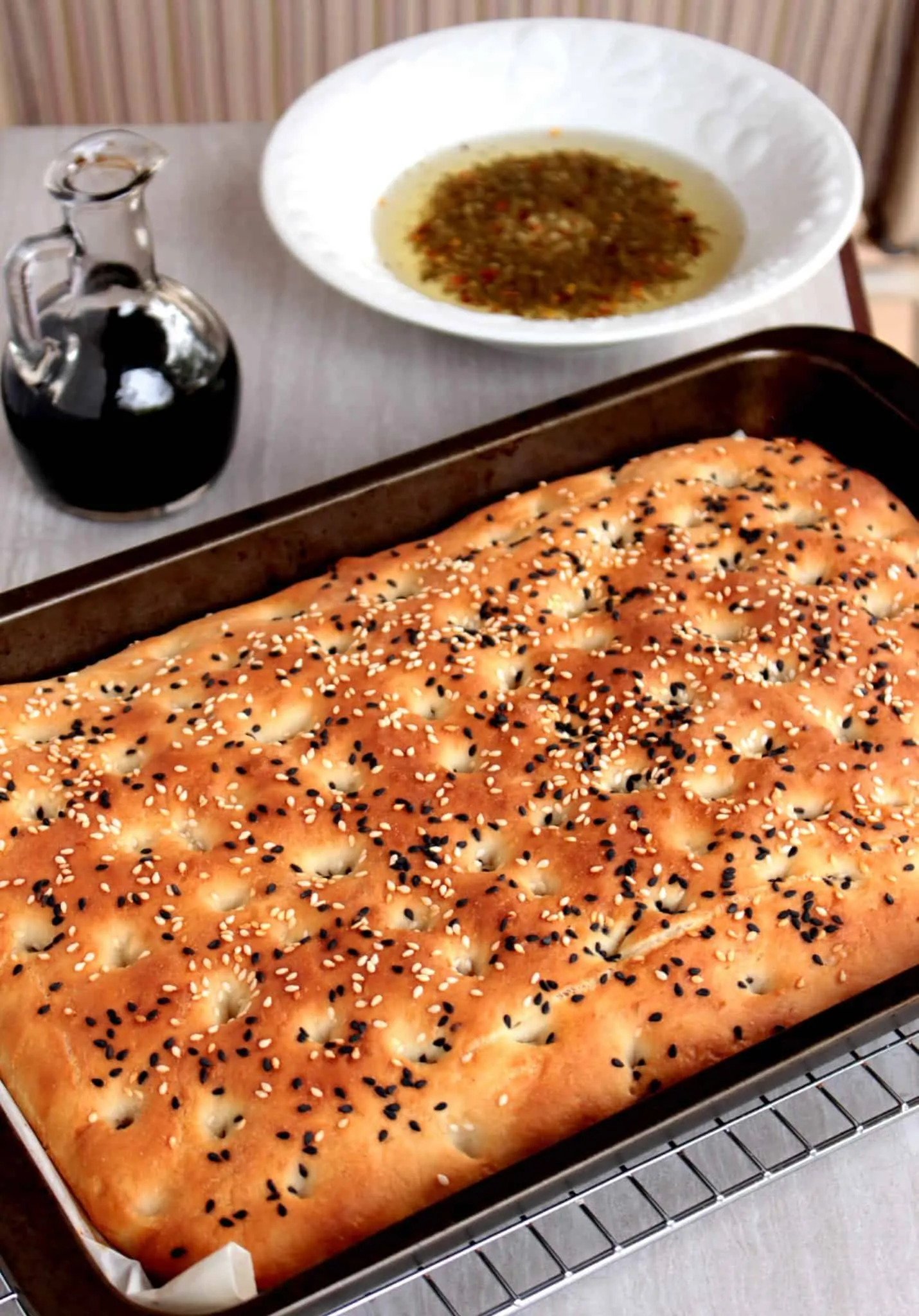 Lagana flatbread in a tray with sesame seeds sprinkled on top. 