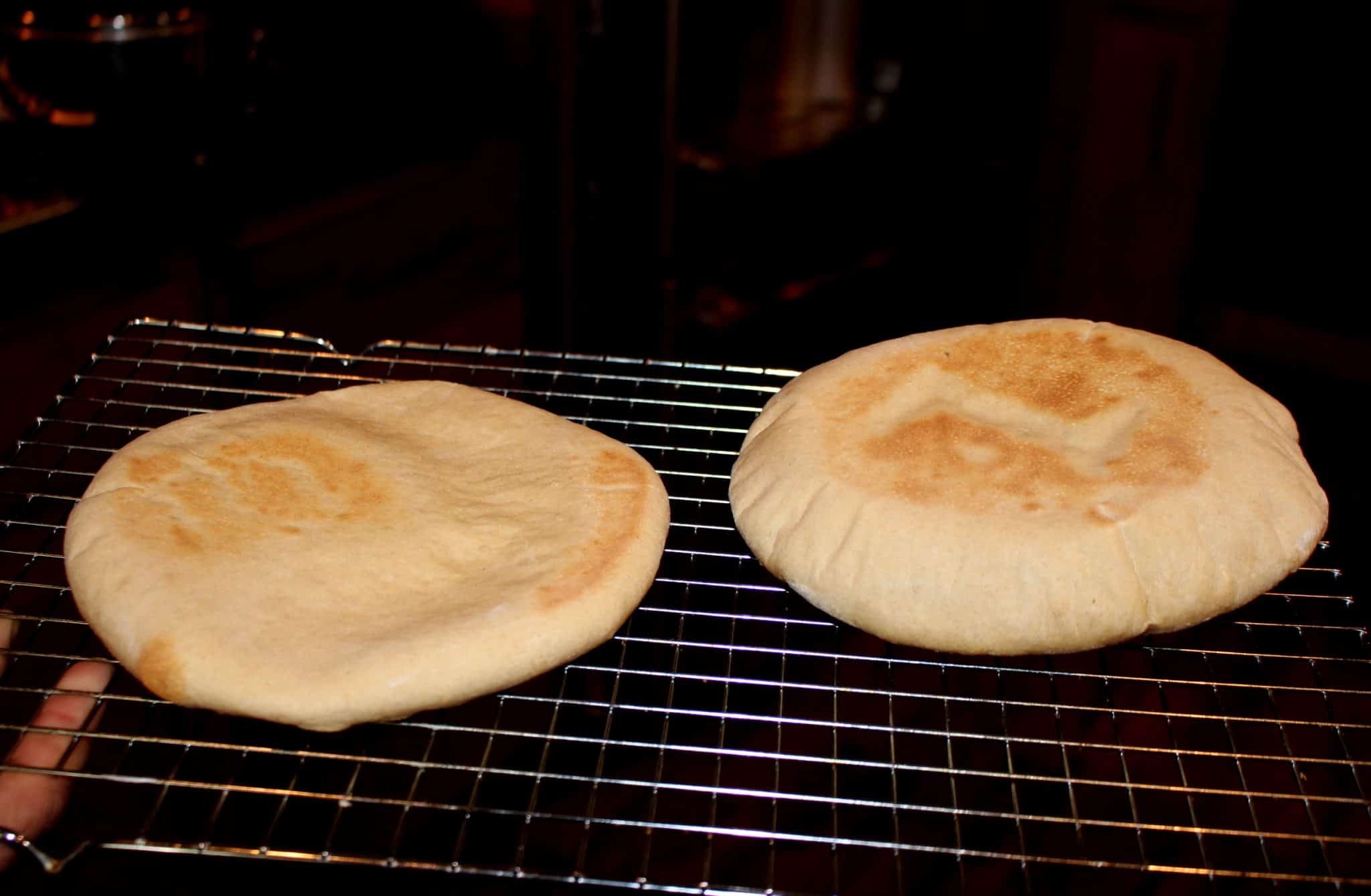 Pita bread on a rack for cooling.