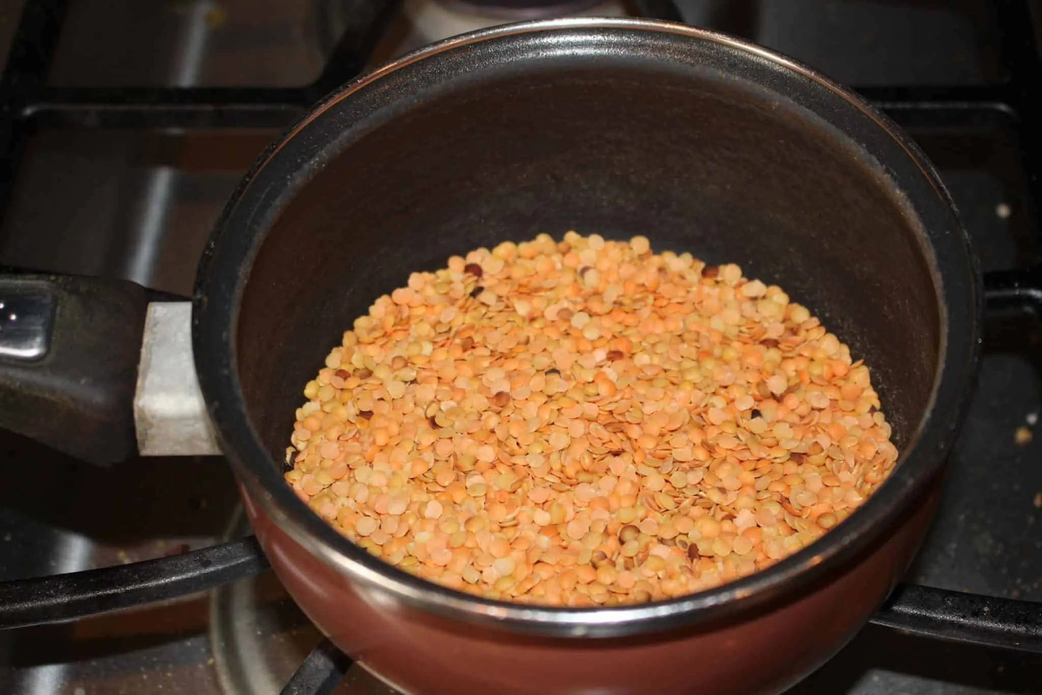roasting orange lentils in a pan