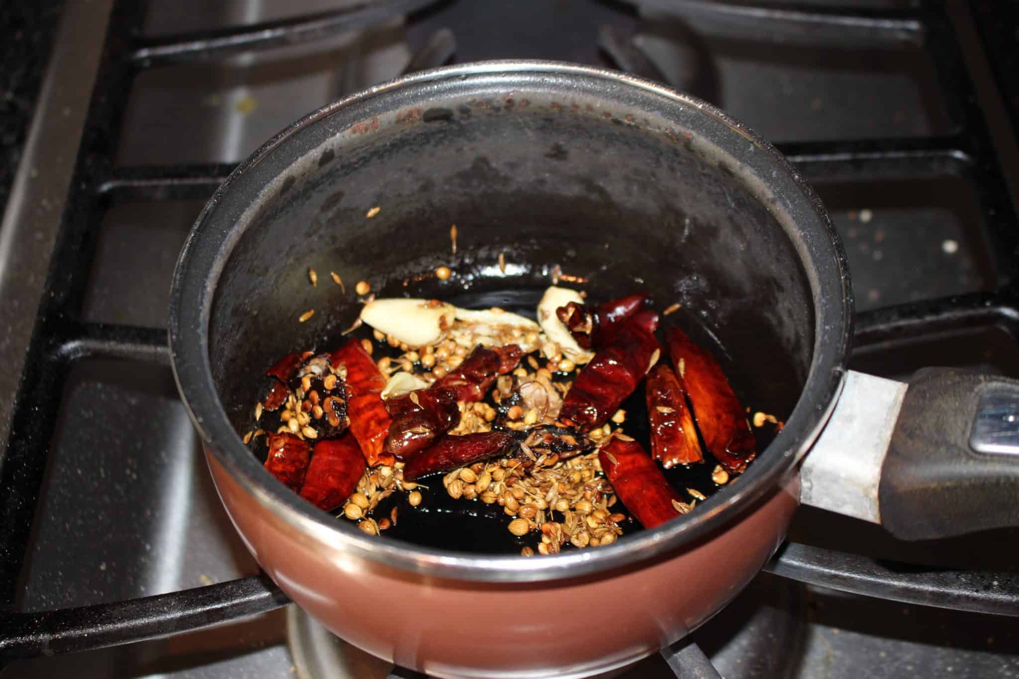 roasting coriander seeds, red chilies, cumin and garlic