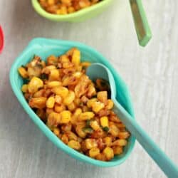 corn salad in a green bowl with spoon