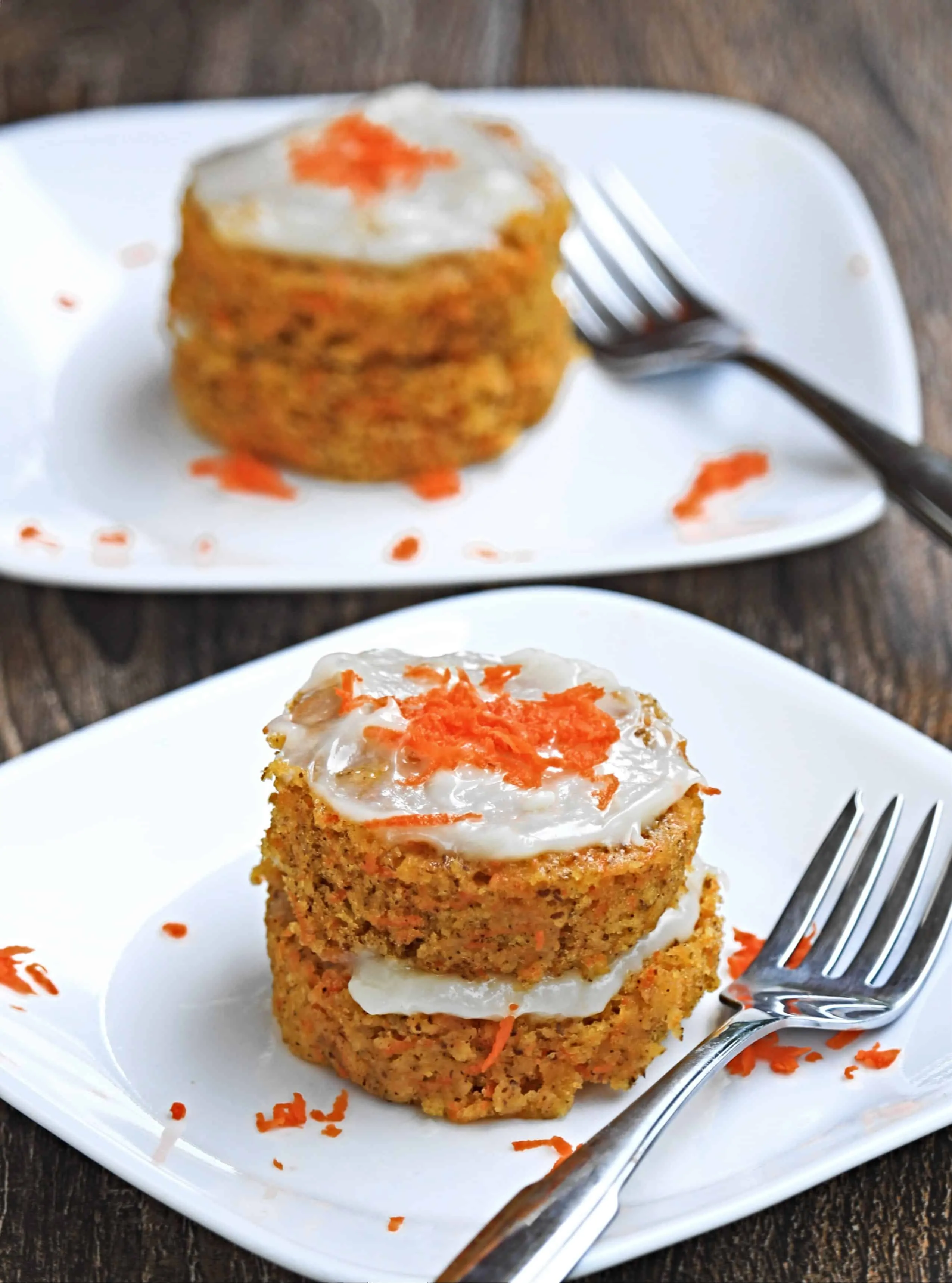 Carrot cake two layered with frosting and carrot grating as garnish