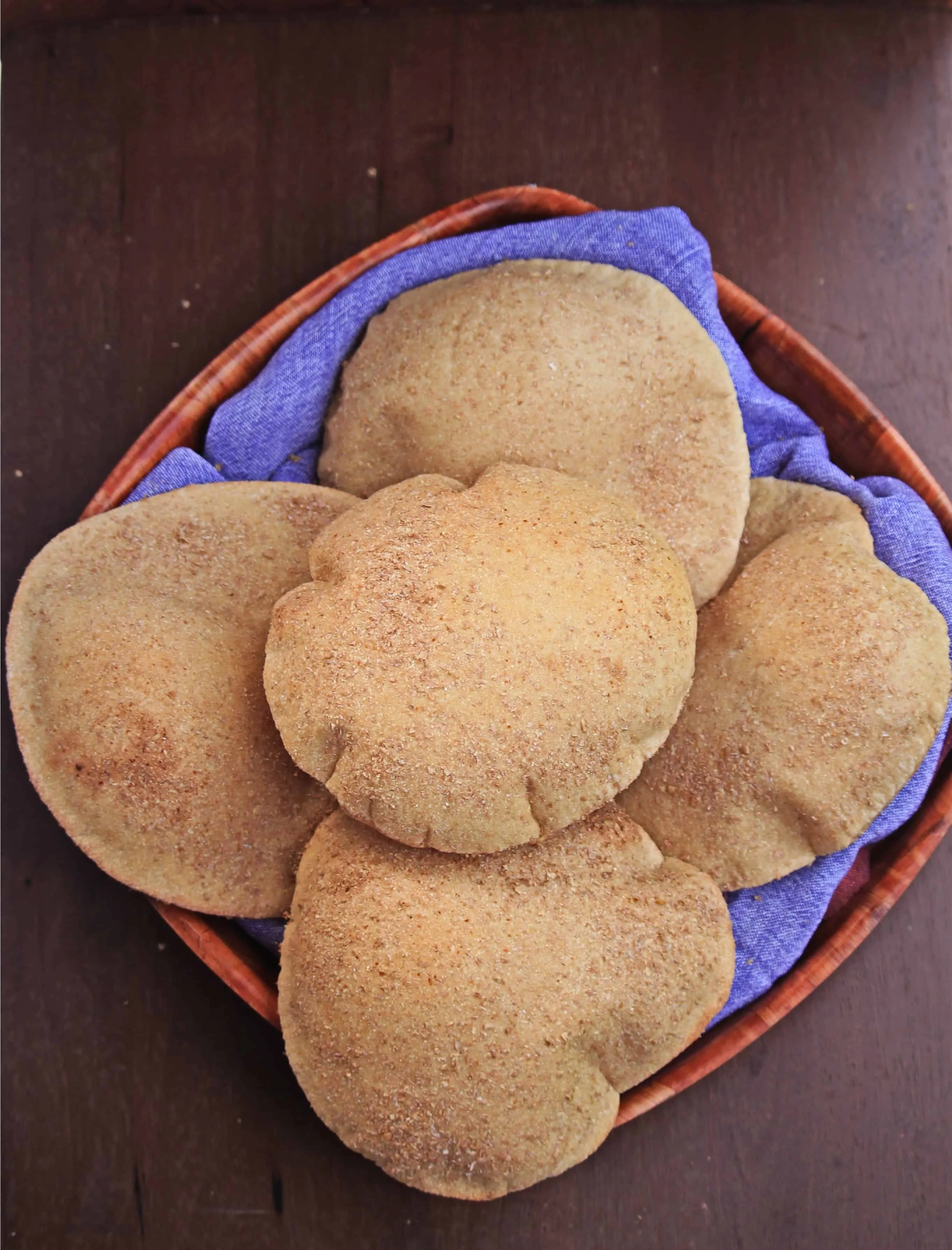 5 aish baladi arranged in a bowl lined with blue towel