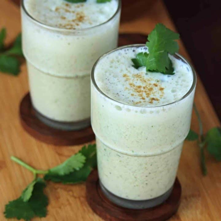 spiced buttermilk in a glass garnished with fresh herb