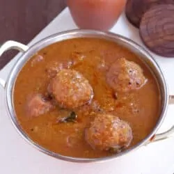 Kuzhambu made with lentil balls in a steel bowl