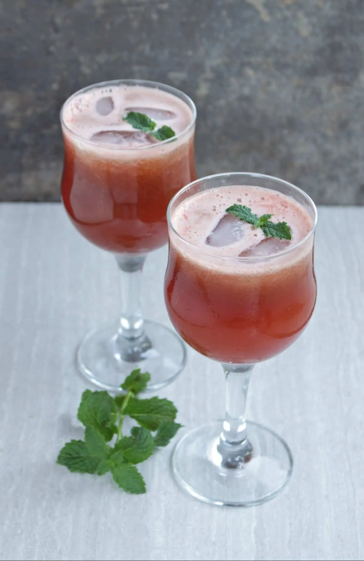 Watermelon juice with mint as garnish in 2 glasses.