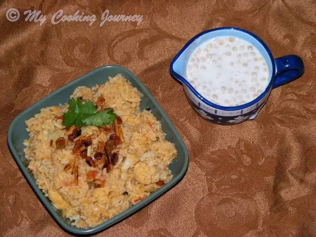 Cauliflower Dum Biriyani in a bowl with raita