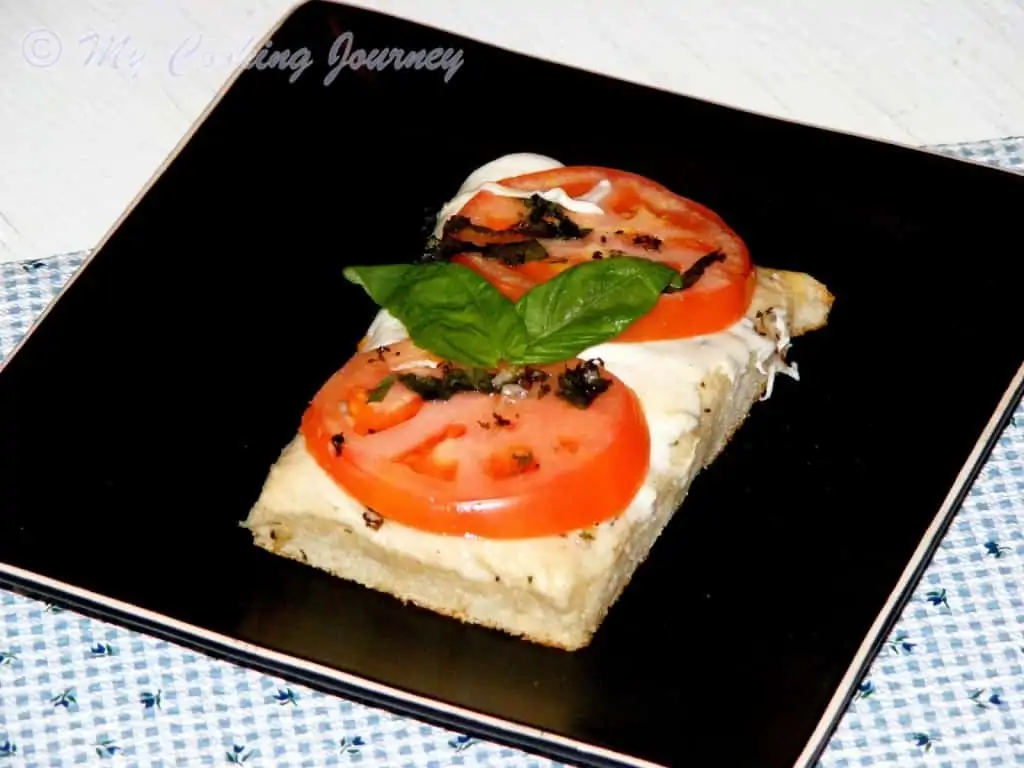 Foccacia Caprese Topped With Tomatoes, Mozzarella and Basil in a tray