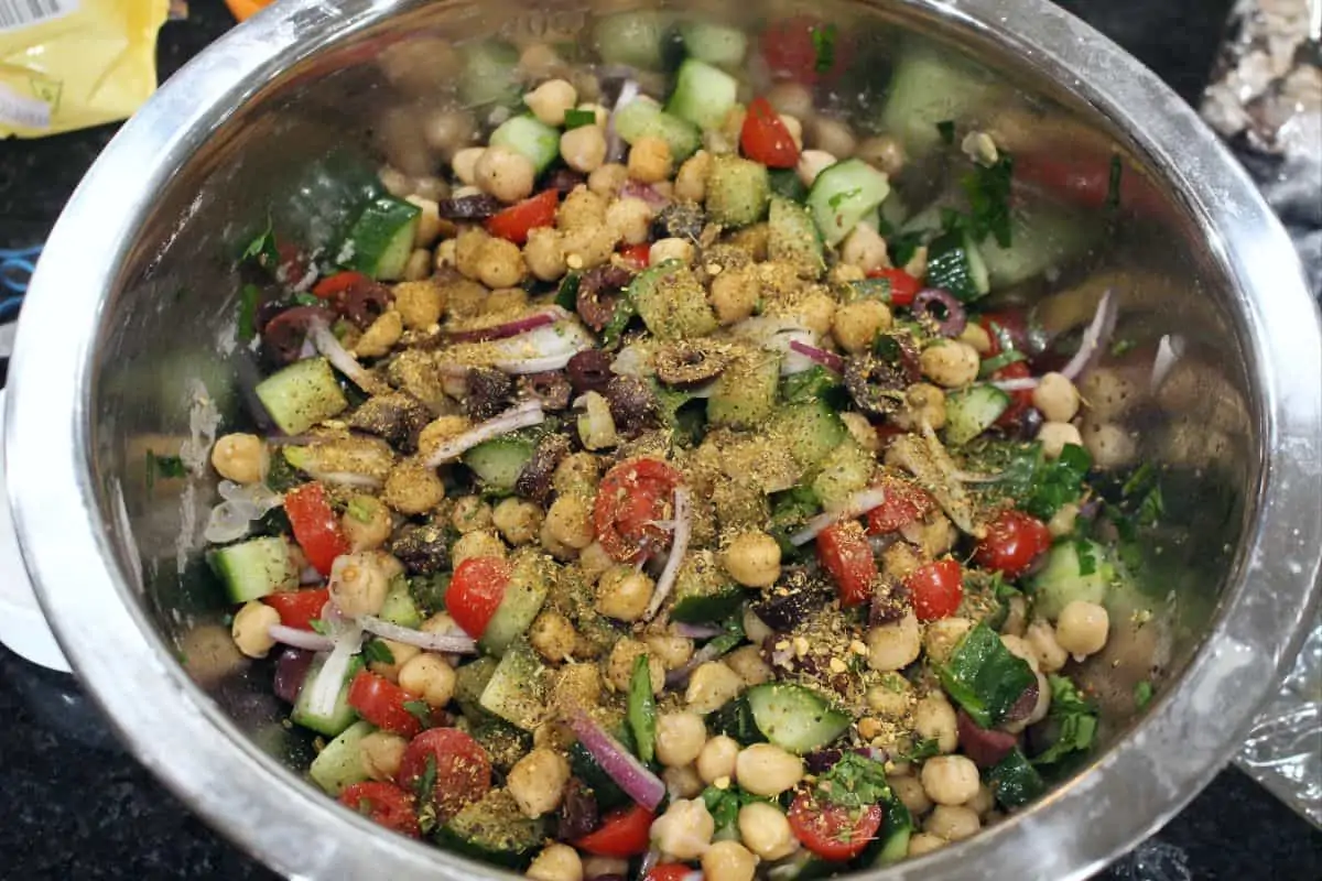 spices added to the salad in a steel bowl