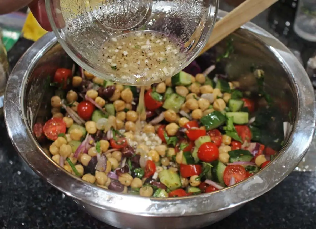 adding dressing to the salad bowl