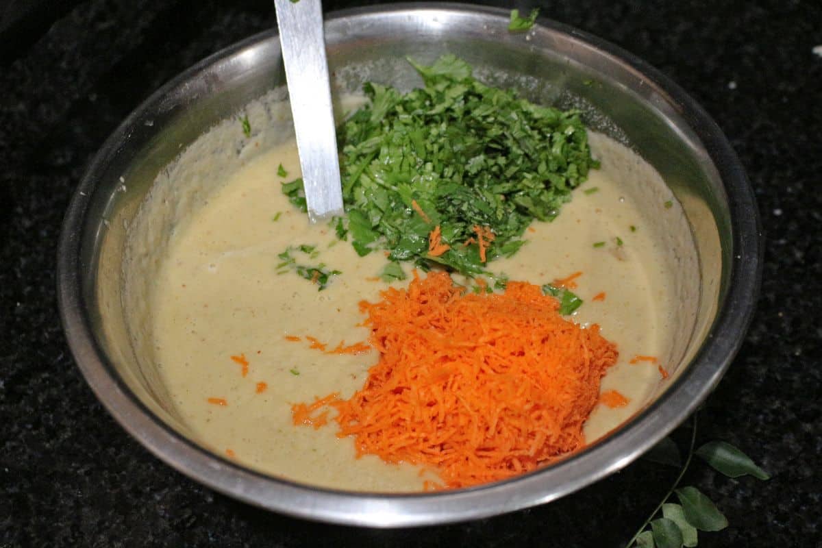 cheela batter with grated carrot and cilantro