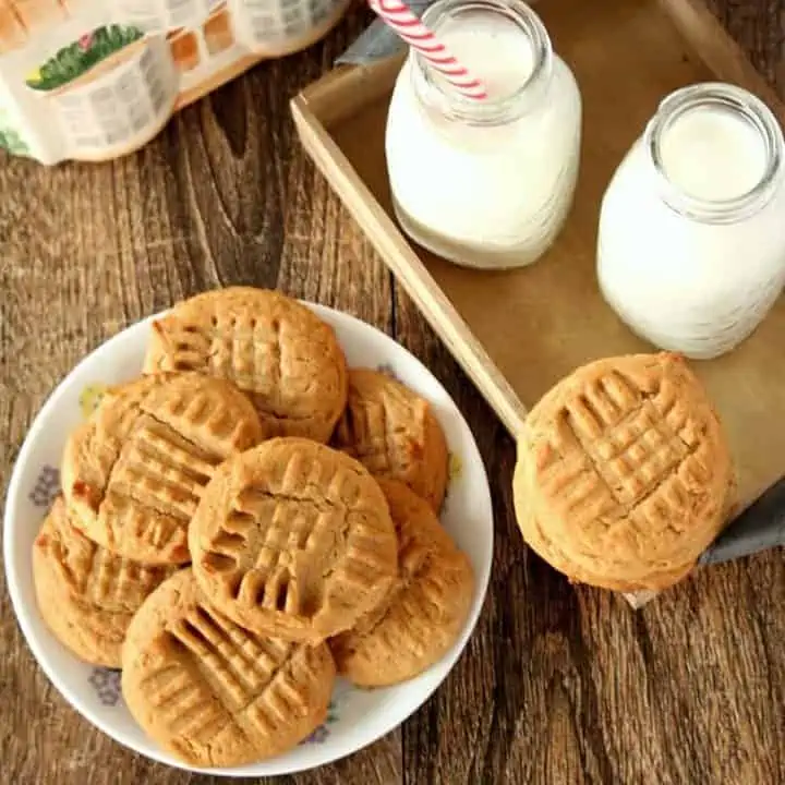 Peanut butter whole wheat cookies with bottle of milk in background - featured image.