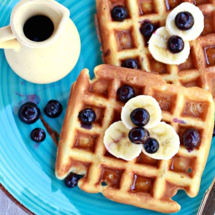 Classic Waffles with banana and blueberry toppings and syrup on the side - Featured Image
