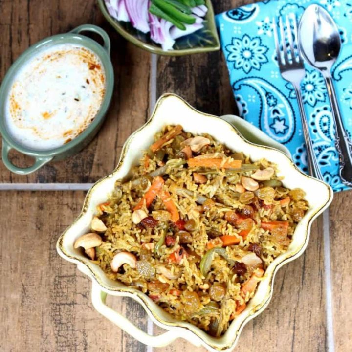Vegetable Biriyani with Yogurt and cut onions and peppers on the side - Featured Image