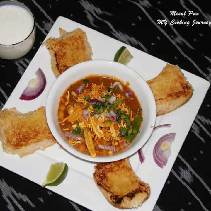 Misal Pav in a plate with some lassi on the side - Featured Image