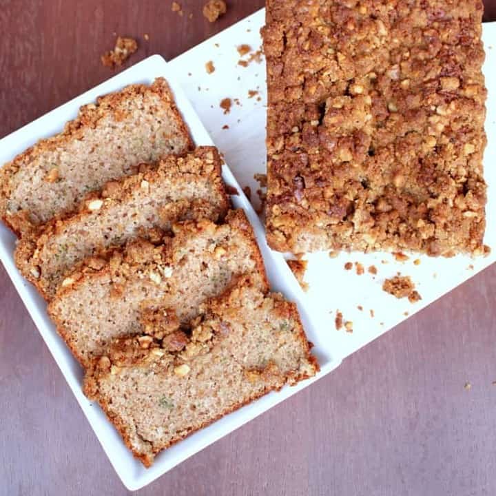 Sliced Zucchini Bread with walnut crumble in a white tray - Featured Image.
