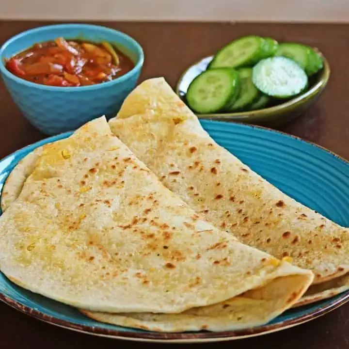 Trinidad Dhal Puri in a blue plate with sides - Featured Image