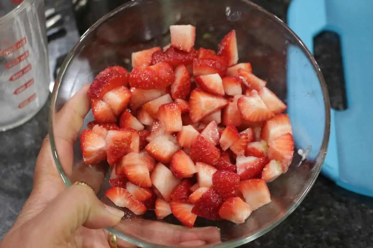 Chopped strawberries in a glass clear bowl.