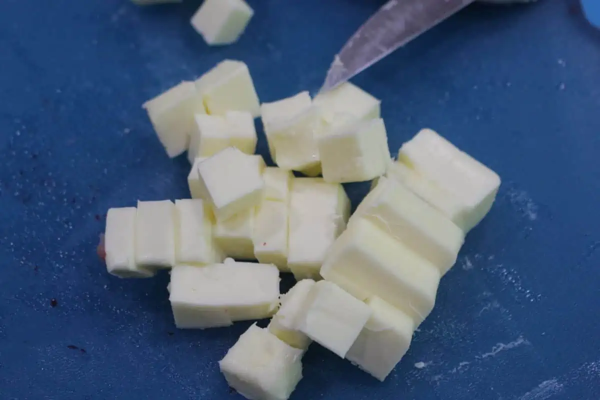 Cubed butter on a blue cutting board.