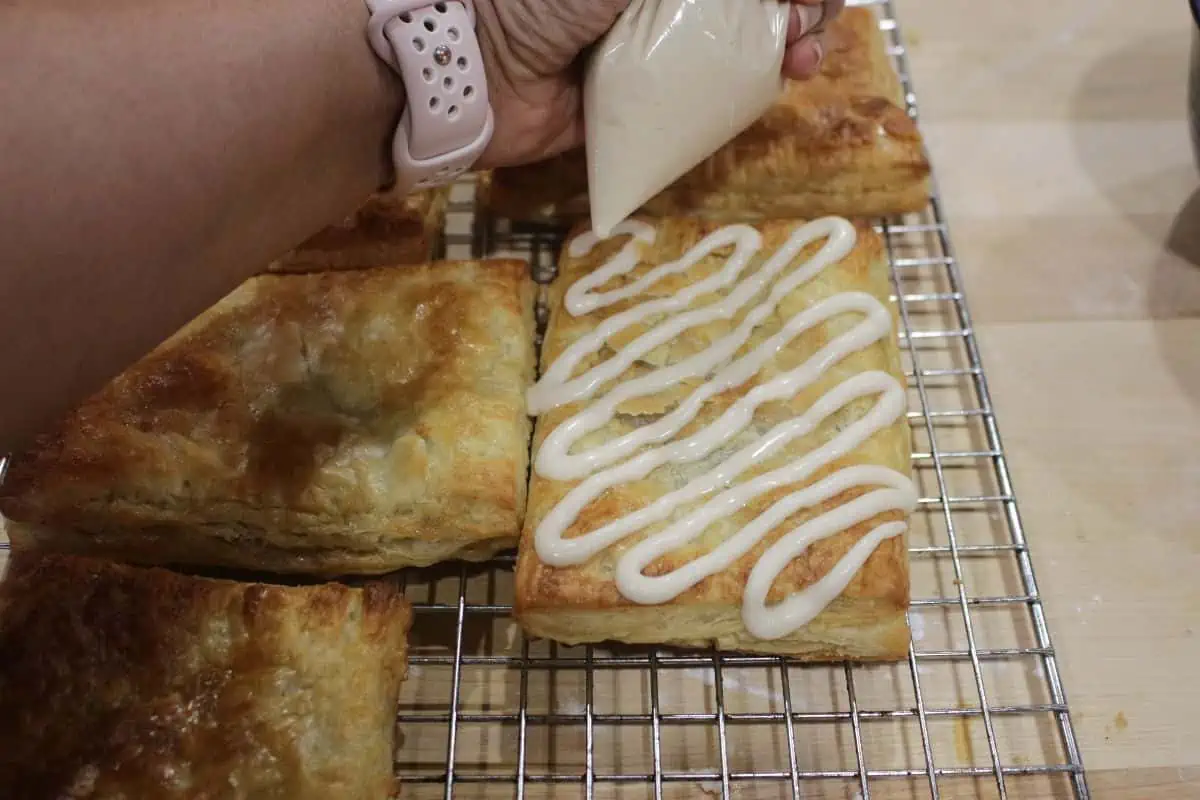 Drizzling icing on a toaster strudel.