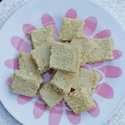 coconut and almond flour burfi stacked in a plate.